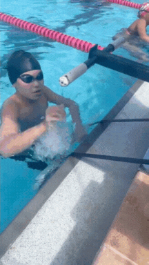 Athlete demonstrating the Spectrum Aquatics Backstroke Start Device with automatic retractability.