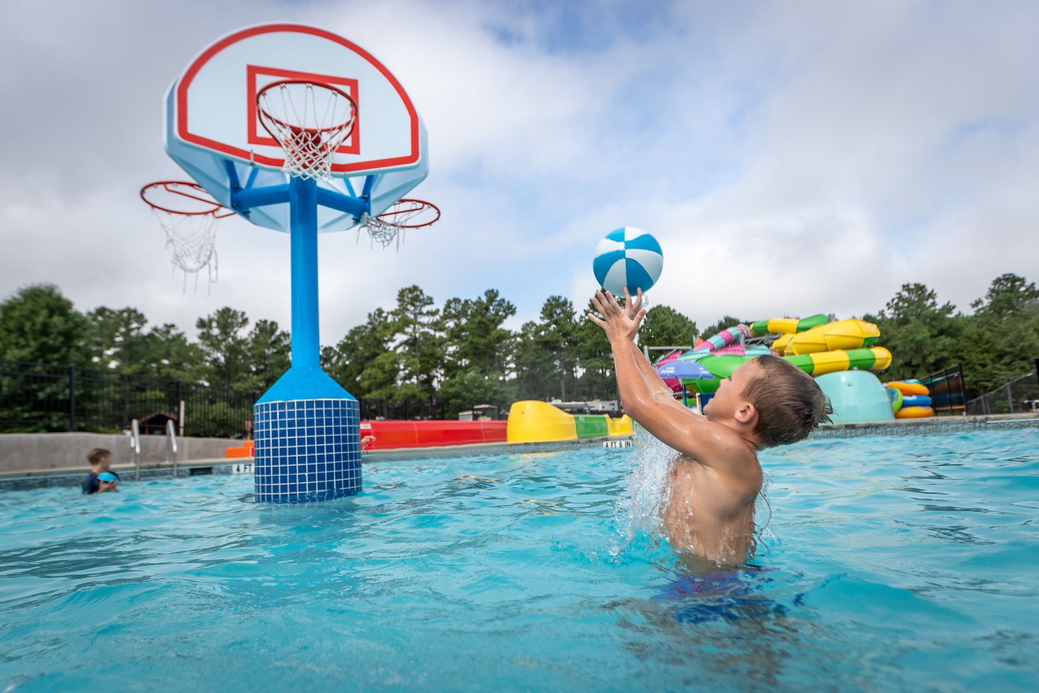 Boy shoot hoops in pool with Spectrum's Recreational Pool Basketball Hoop