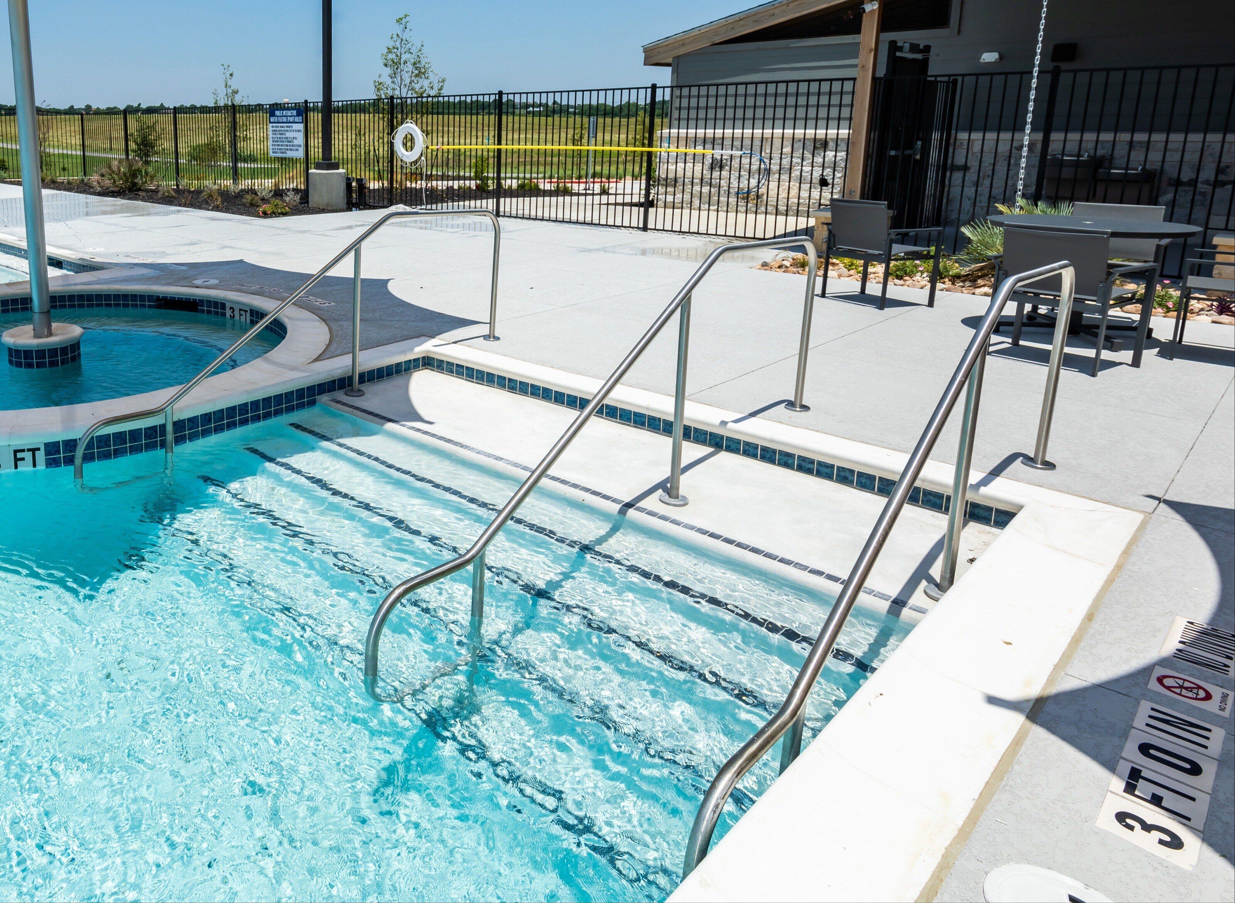 Stainless steel ramp and pool handrails at outdoor pool 
