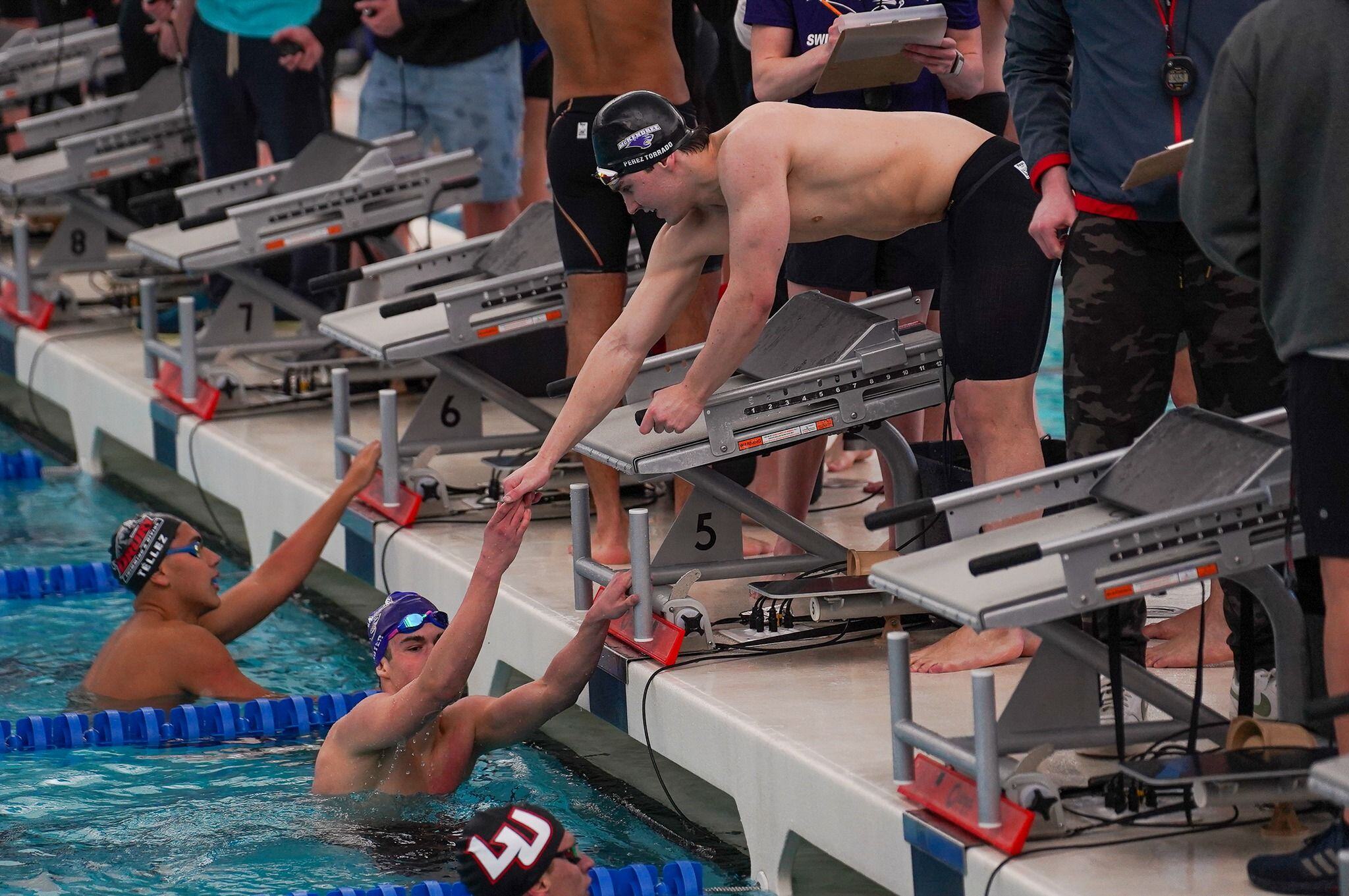 Athletes congratulating each other on Xcellerator swim starting blocks