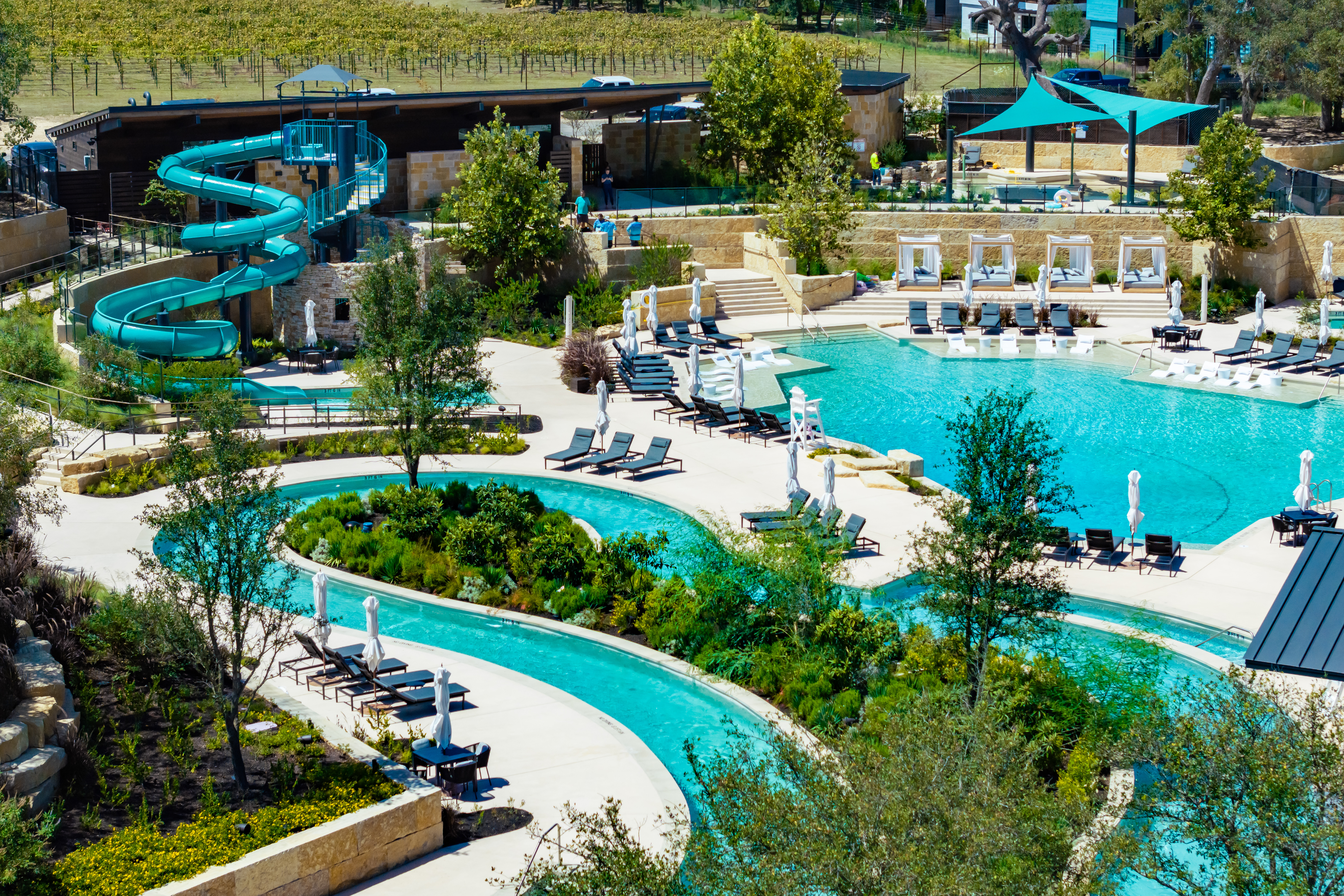 Outdoor recreational aquatic center with a lazy rivers, water slides, and custom stainless steel rails.