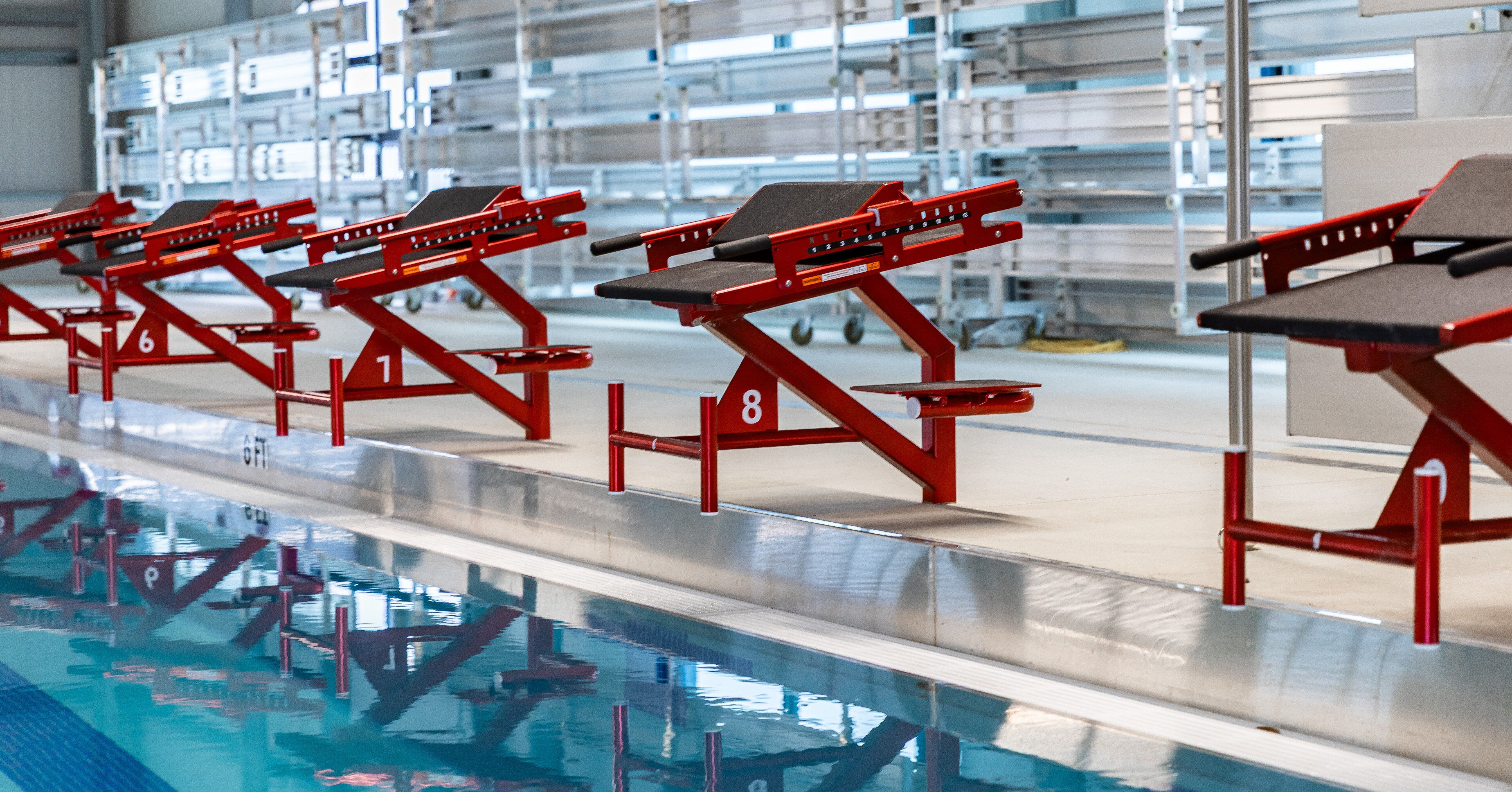 Custom powder coated stainless steel Xcellerator swim starting blocks at indoor pool