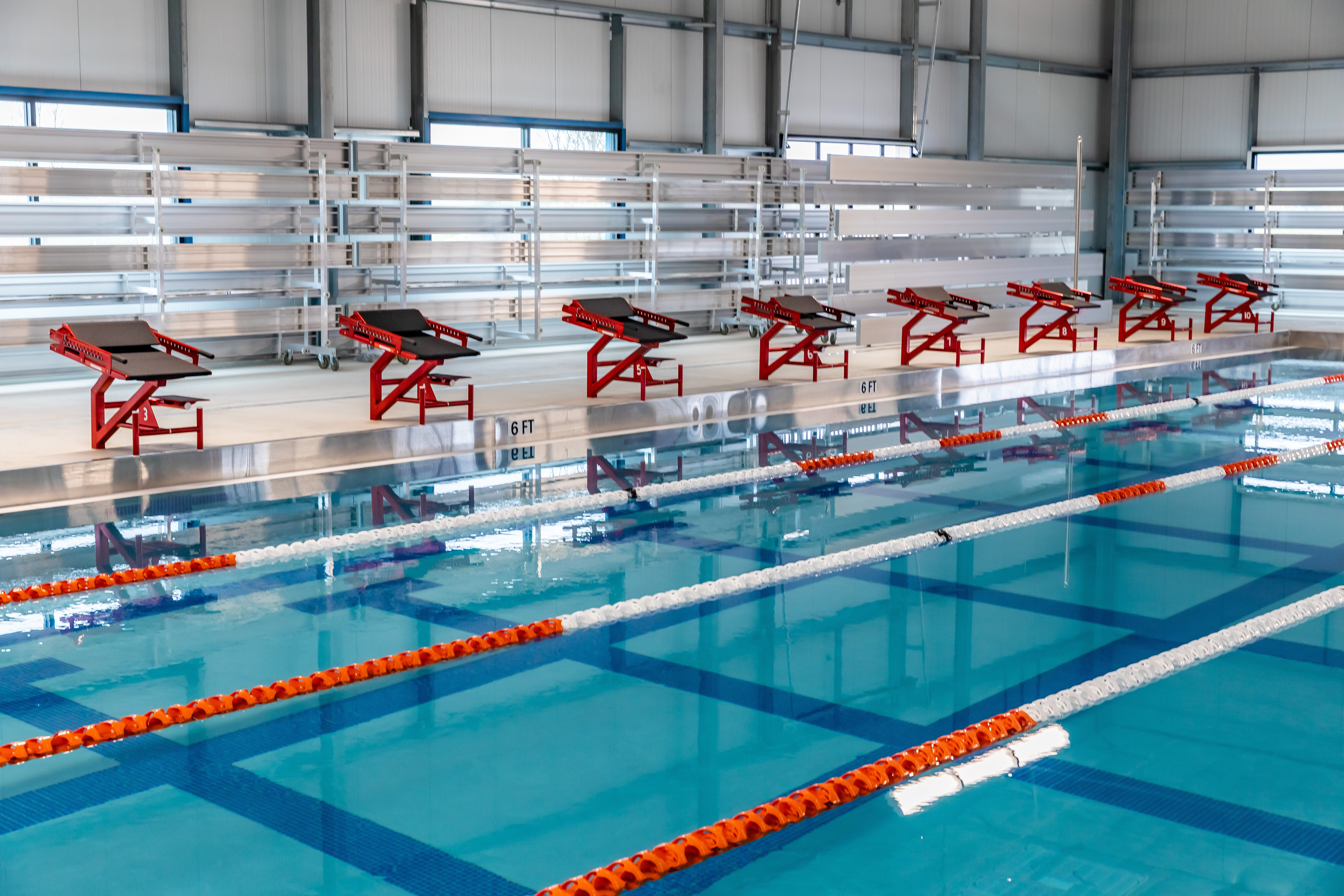 Row of custom powder coated stainless steel Xcellerator swim starting blocks