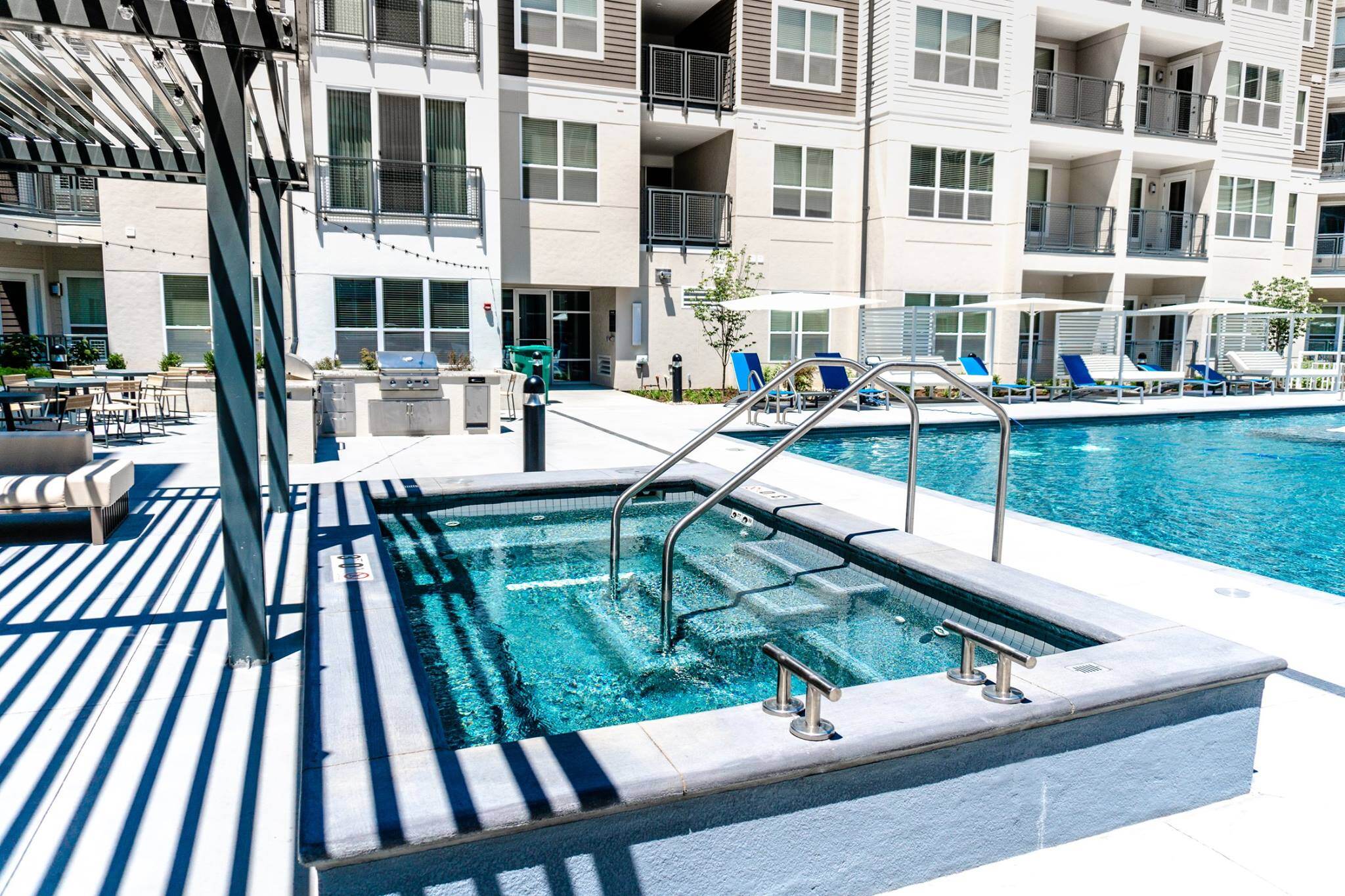 Outdoor pool with stainless steel transfer rails for those with mobility constraints.