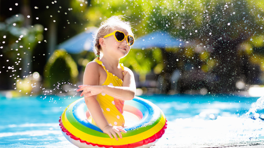 Little girl standing out at a swimming pool
