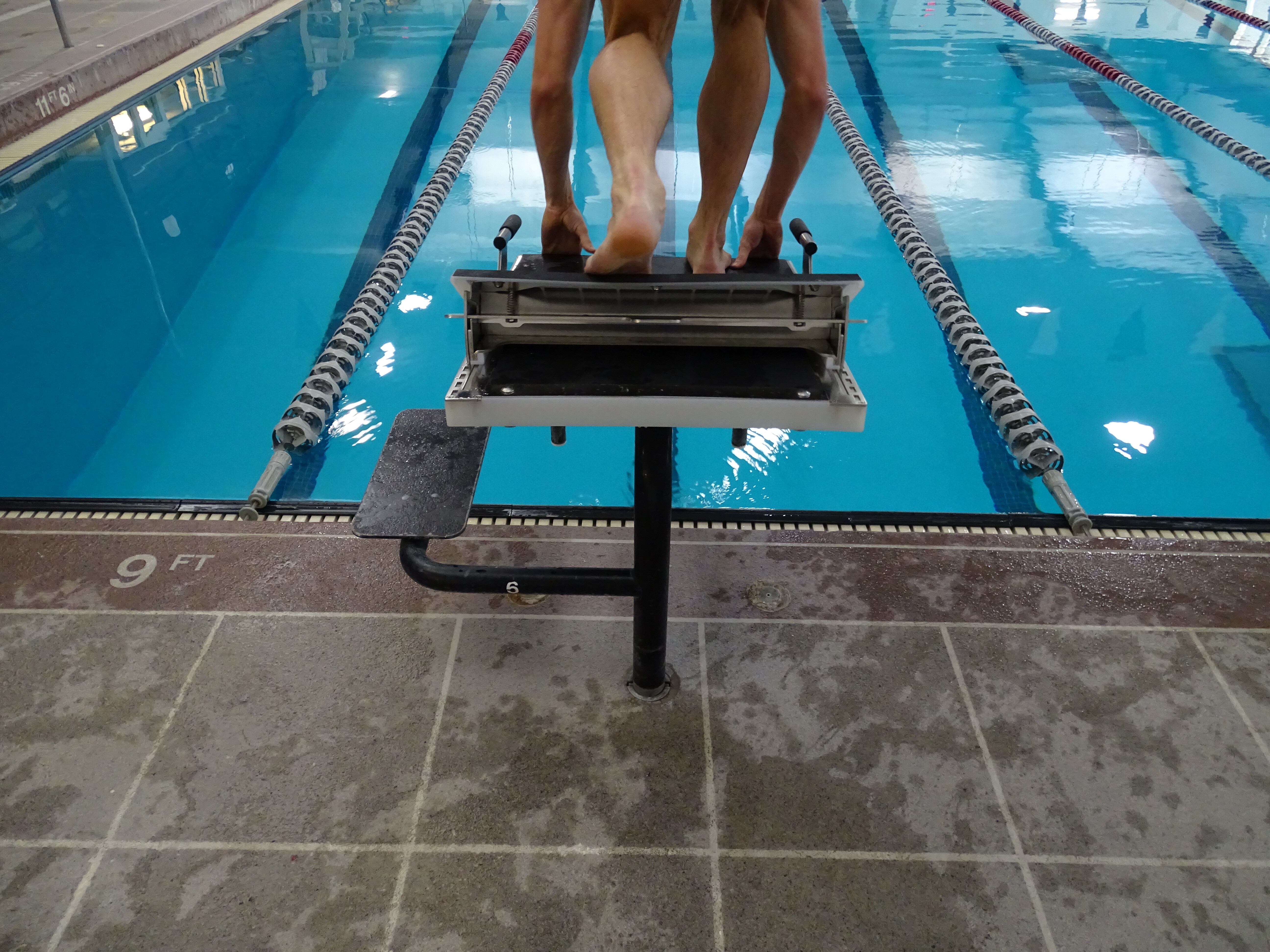 Athlete at their mark on Sprint Swim Starting Block with Rapid Lock, behind view