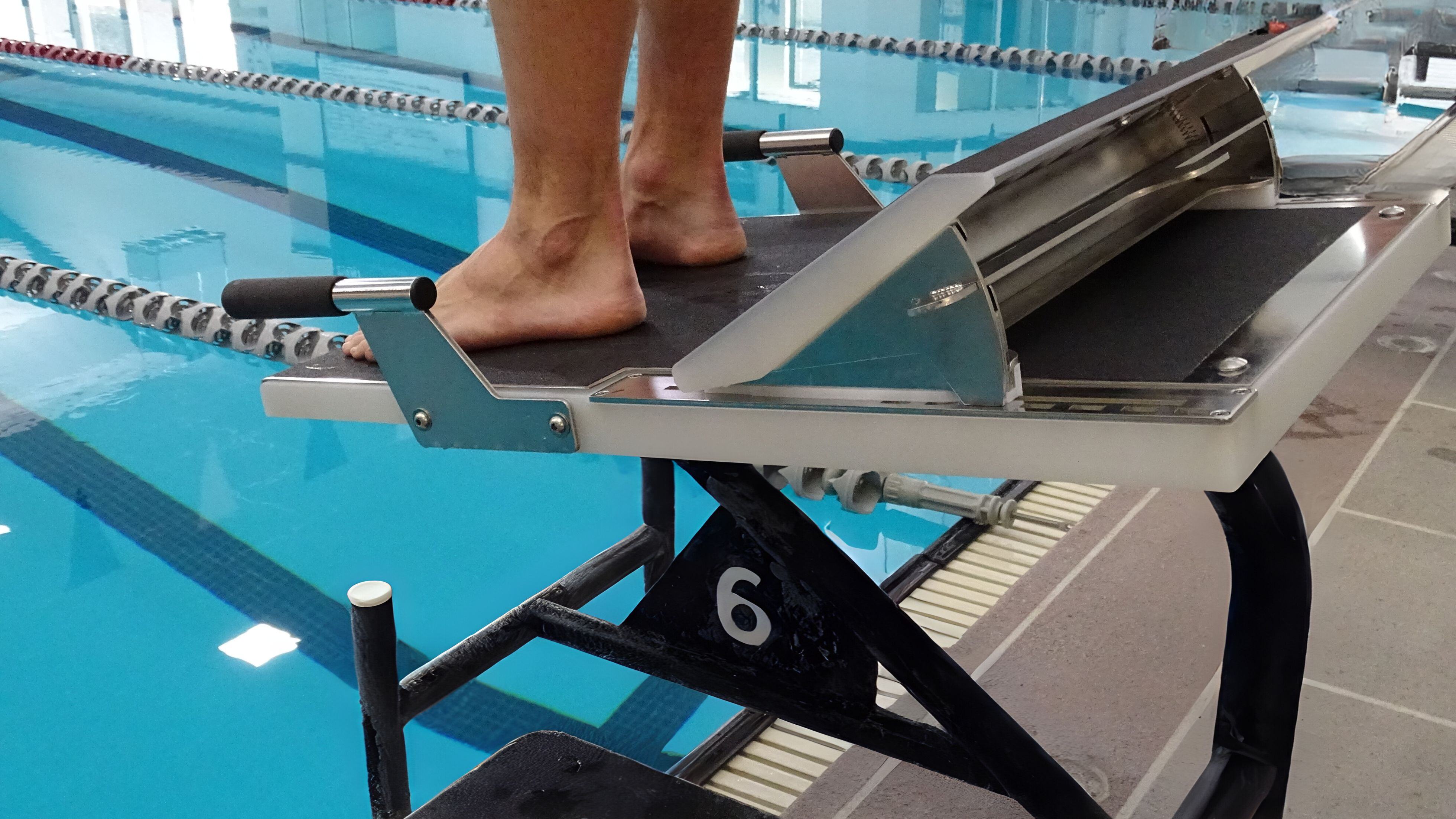 Athlete standing on Sprint swimming starting block with Rapid Lock